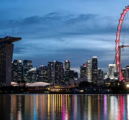 Нічний краєвид Сінгапуру з Marina Bay Sands і червоним колесом огляду над водою