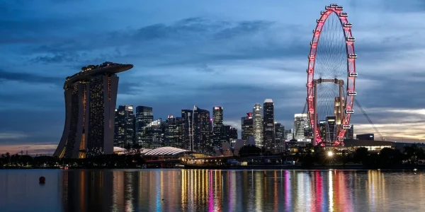 Нічний краєвид Сінгапуру з Marina Bay Sands і червоним колесом огляду над водою